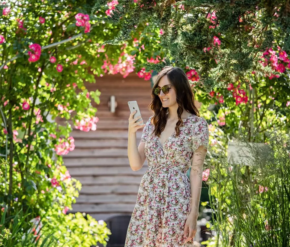 Frau mit Smartphone im Garten